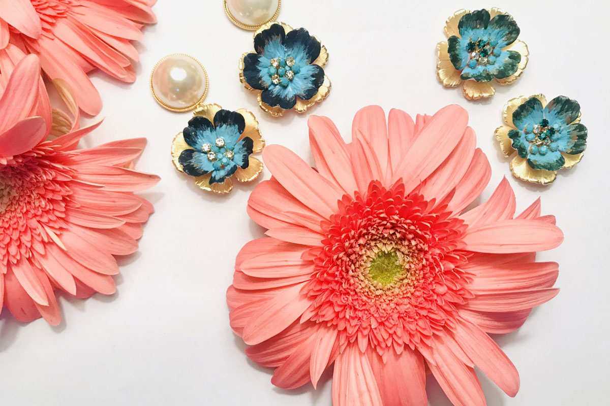 blue floral earrings with a pink flower