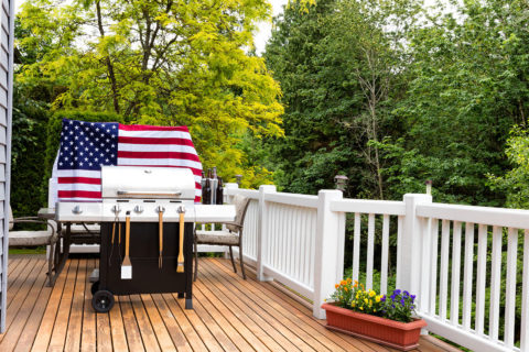 grill on back patio of house in front of american flag
