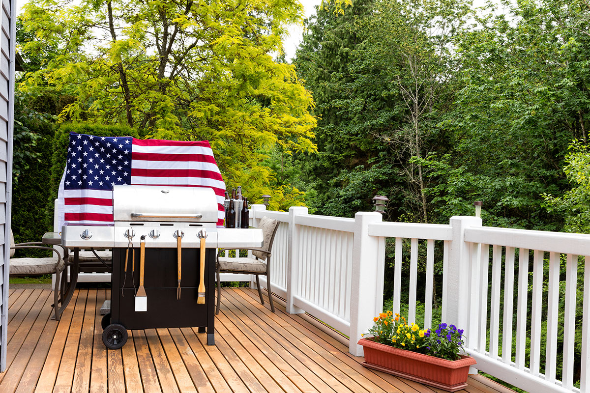 grill on back patio of house in front of american flag