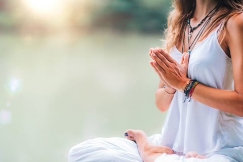 woman in white in om position with hands together