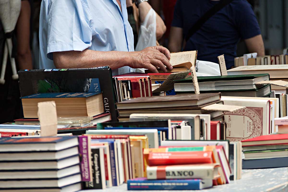 Man looking through stack of books