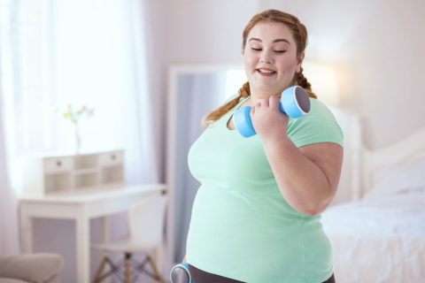 woman working out with weights in her bedroom