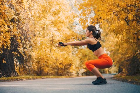 woman doing squats outside