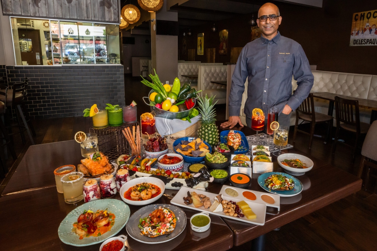 Santosh Tiptur with dishes from La Prensa. (Photo by Andrew Sample)