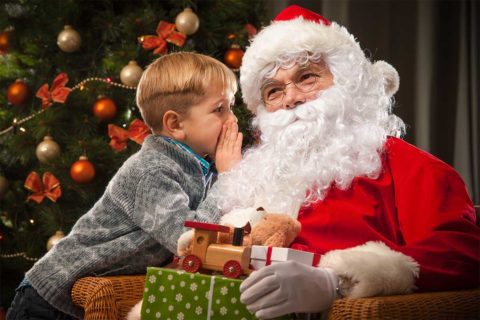 kid whispering in santa's ear