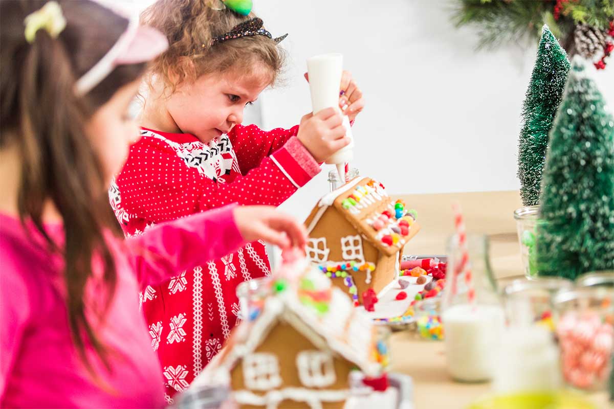 two kids decorating gingerbread houses
