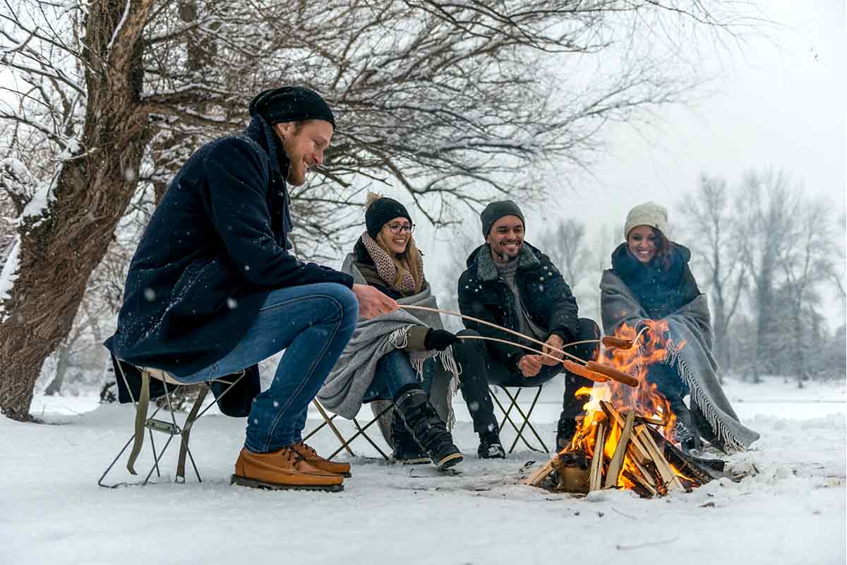 group toasting marshmallows over fire