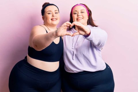 Two women making heart with hands