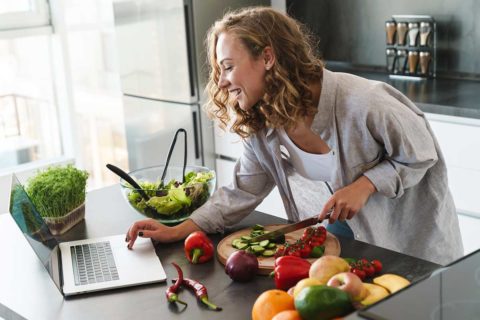 woman cooking by computer