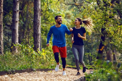 man and woman running on trail