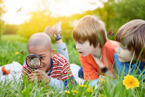 boys looking through magnifying glass