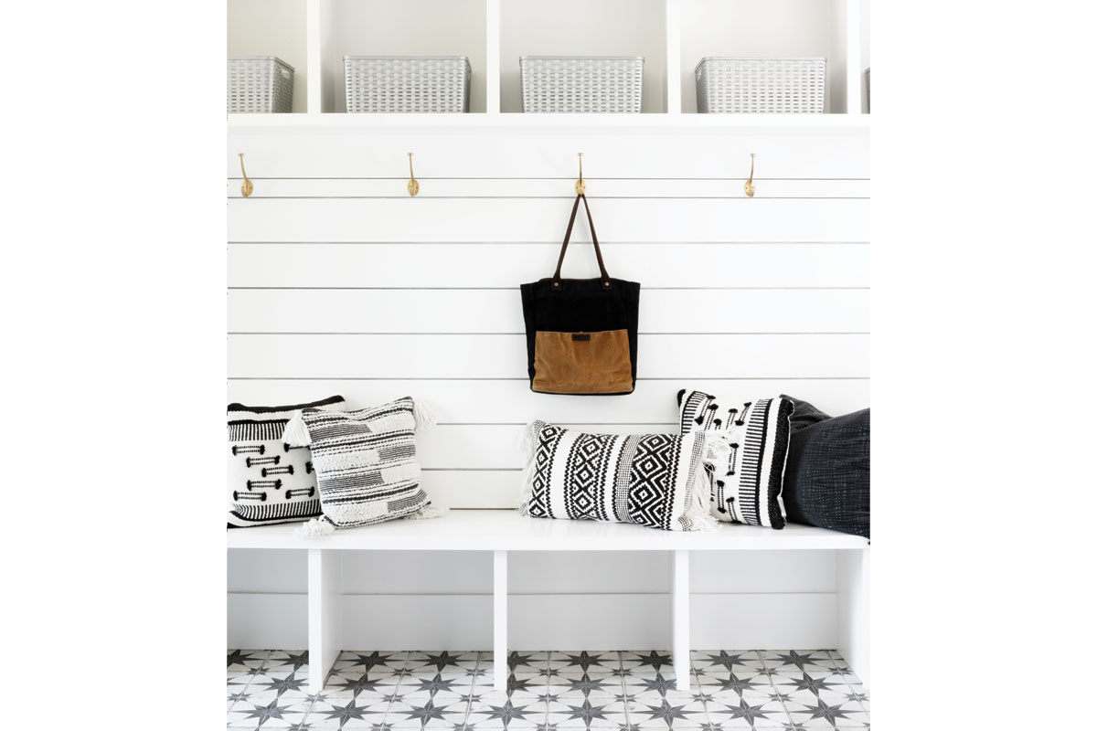 white mudroom with black and white pillows and flooring