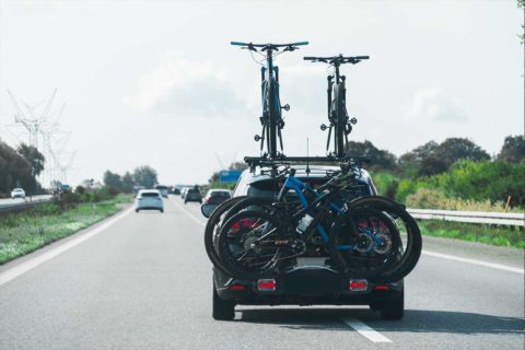 car driving down road with bike rack