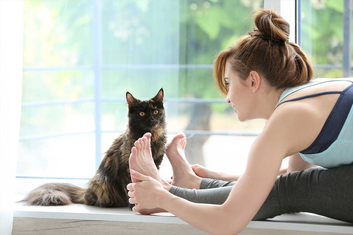 woman doing yoga with cat