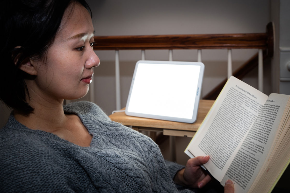 woman reading with sad lamp