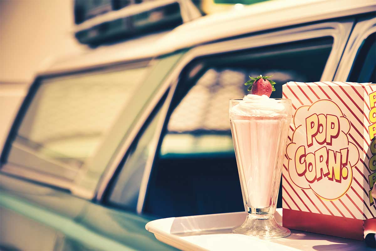 popcorn and milkshake on side of car