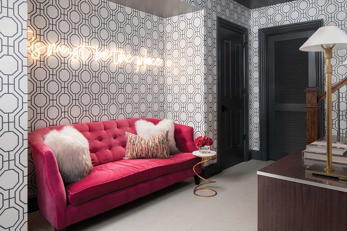 pink couch in room with geometric wallpaper