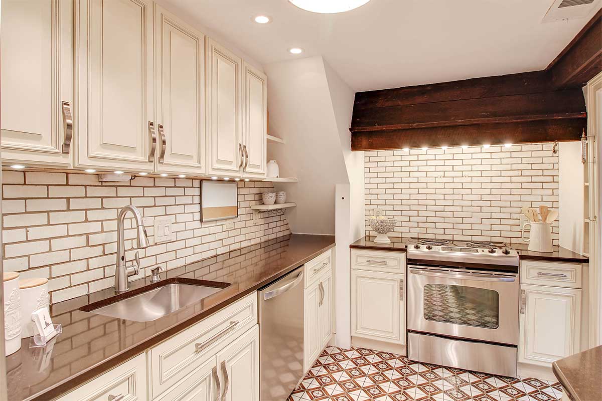 white and cream colored kitchen with brick accents