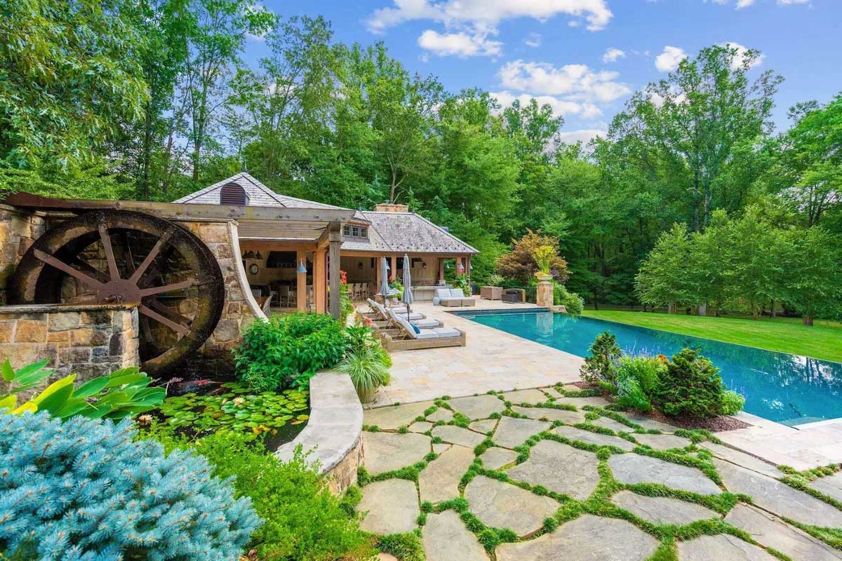 landscaped yard with pool and pond