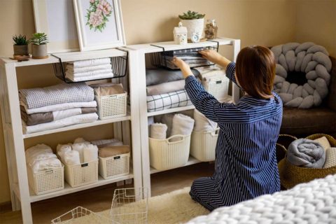 woman organizing sheets in room