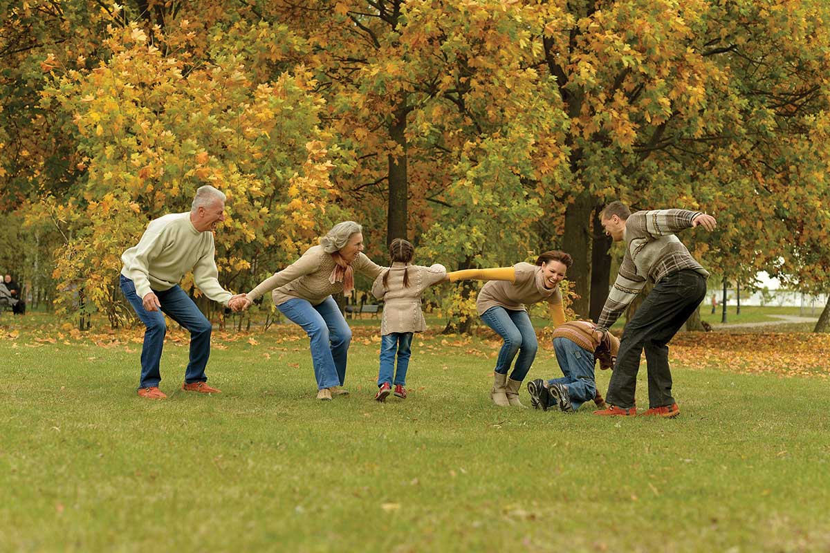 grandparents playing with children in park