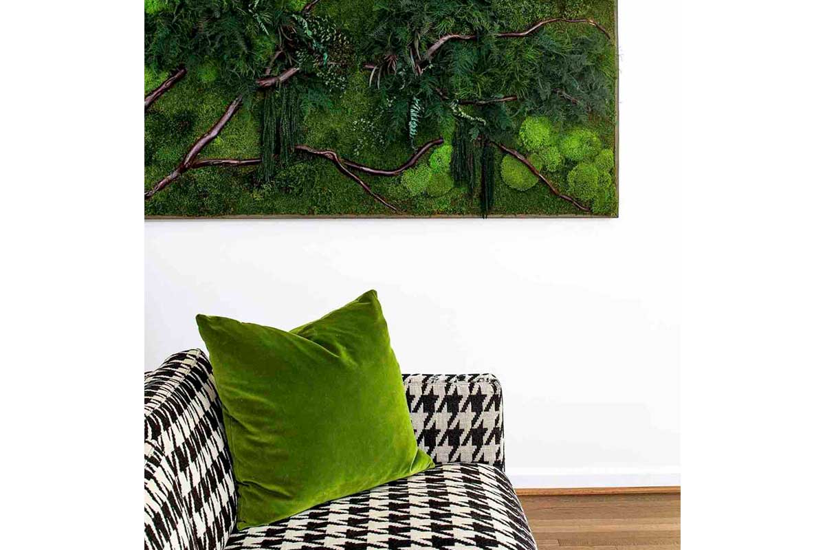 green pillow and art with patterned couch