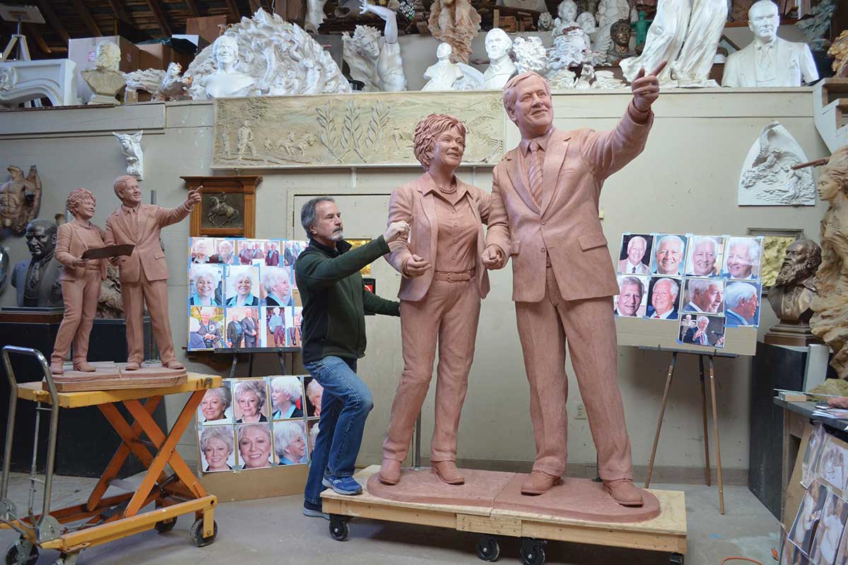 Jeff hall works on a sculpture of Bob and Judy Fisher