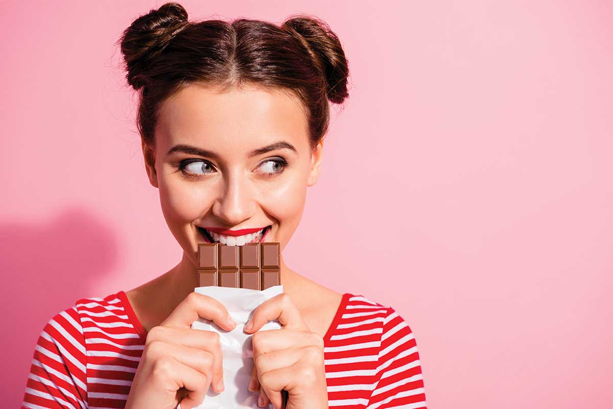 woman eating bar of chocolate