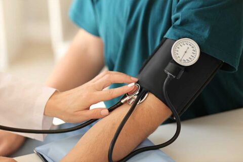 doctor taking patient's blood pressure