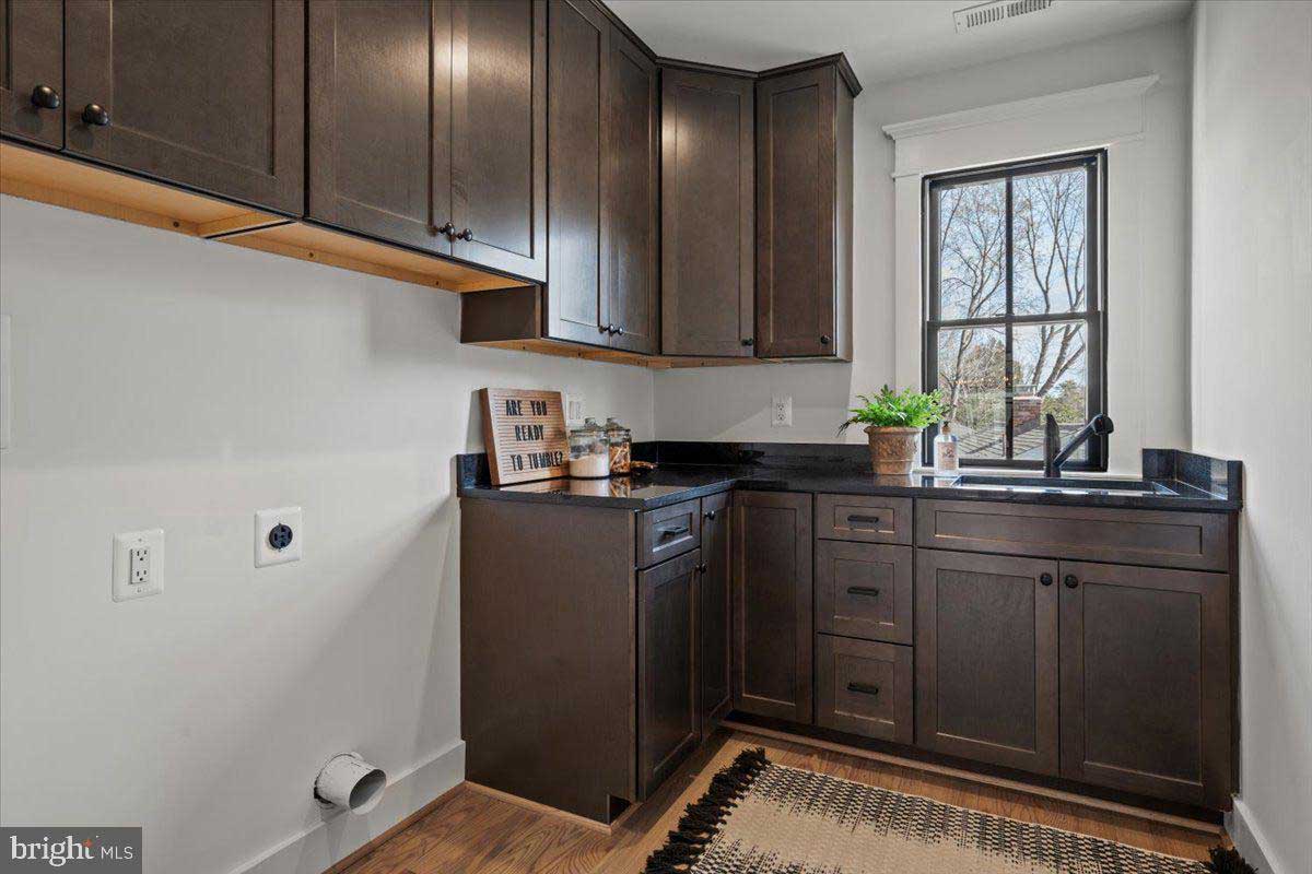 laundry room with dark cabinets