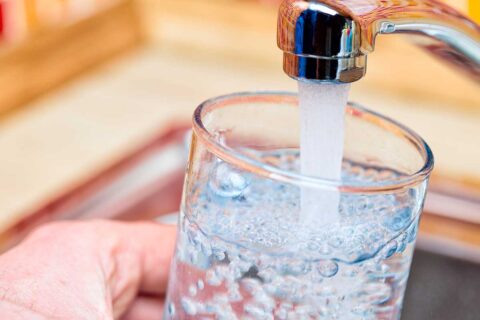 tap water running into a glass from a faucet