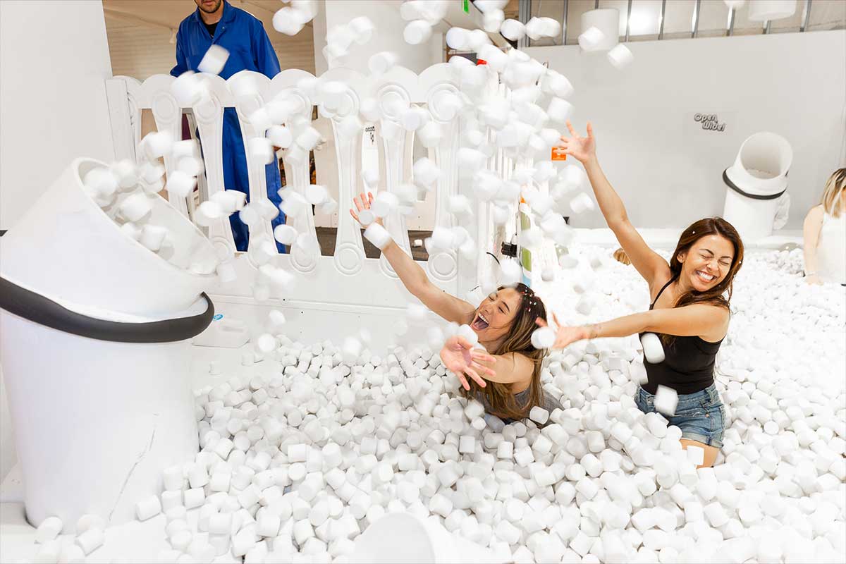 Two women play in the marshmallow pit
