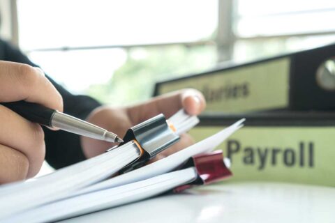man looking at payroll documents