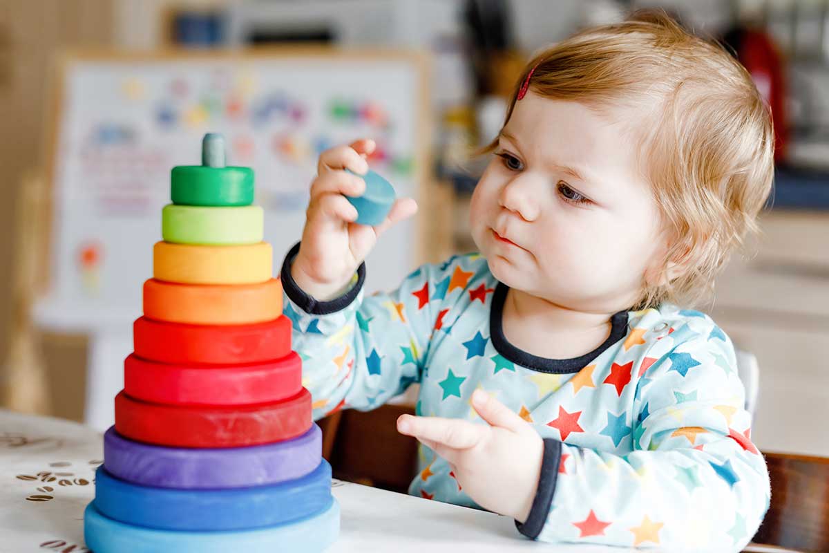 child playing with a colorful toy