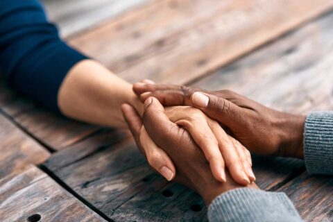 two lonely people holding hands