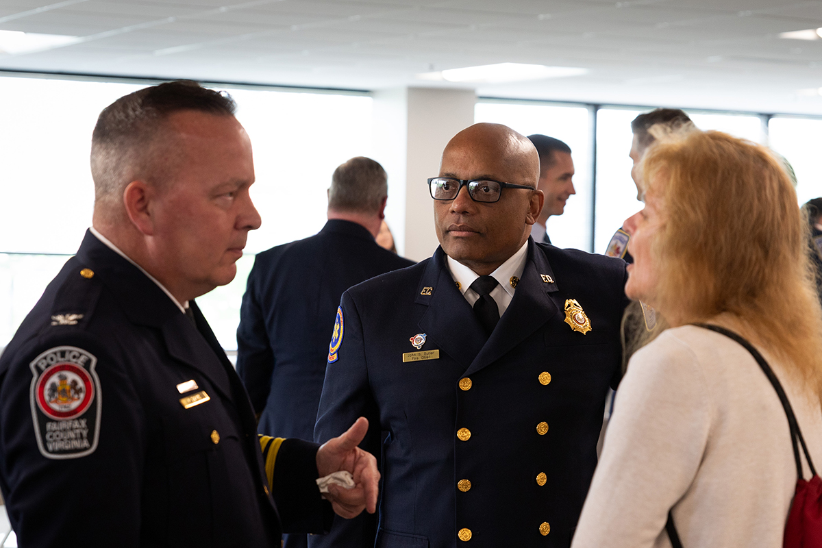 Fairfax County police Chief Kevin Davis and Fairfax County fire Chief John Butler speak with an attendee at the grand opening. (Photo courtesy Fairfax County Police Department)