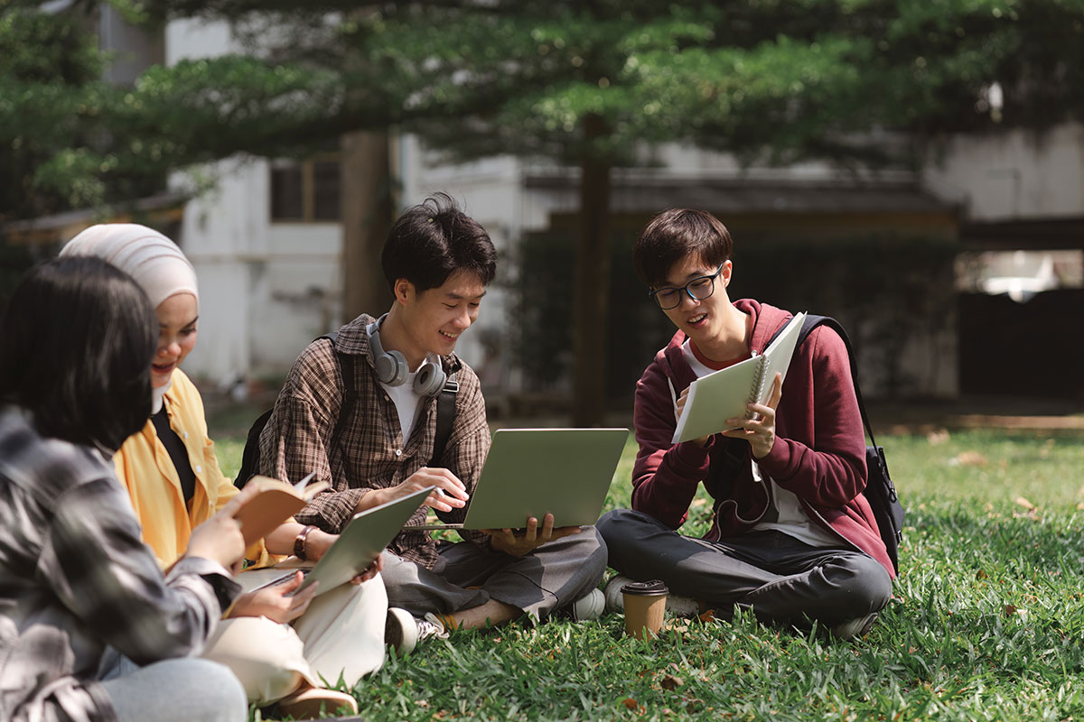 Group of college students studying on a lawn