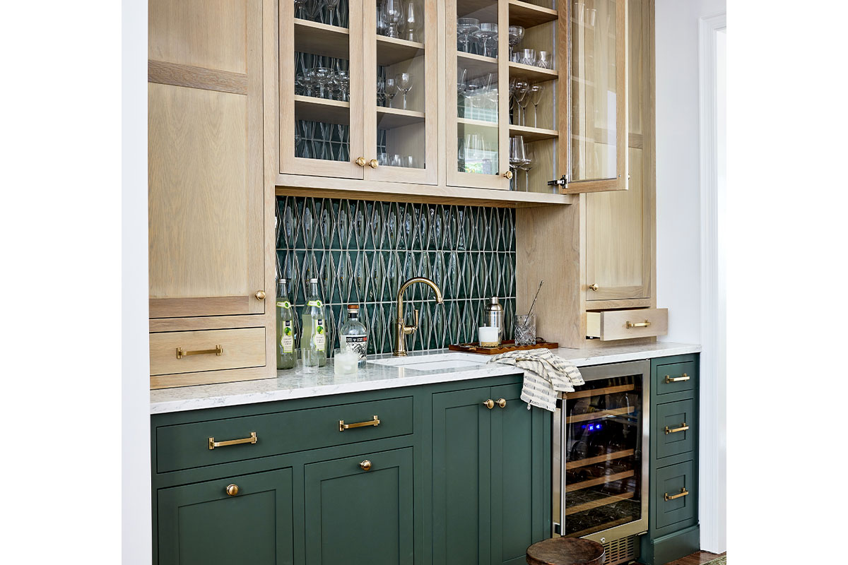 Kitchen bar with green cabinets, green tile backsplash, and white wood cabinets.