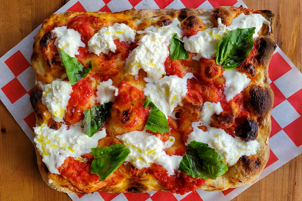 Pizza with tomato sauce, mozzarella, and basil.