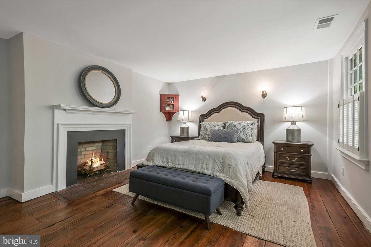 bedroom with fireplace and wood floors at 126 Prince St.