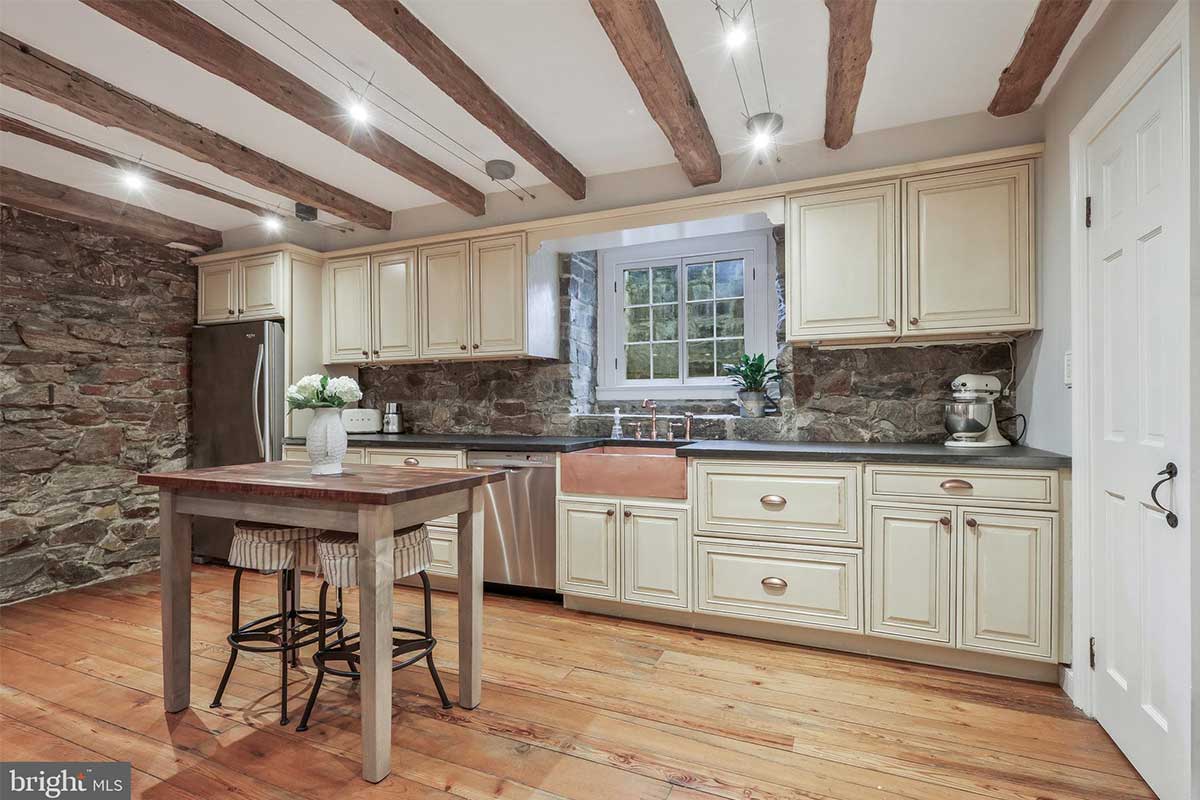 kitchen with cream-colored cabinets and exposed beams