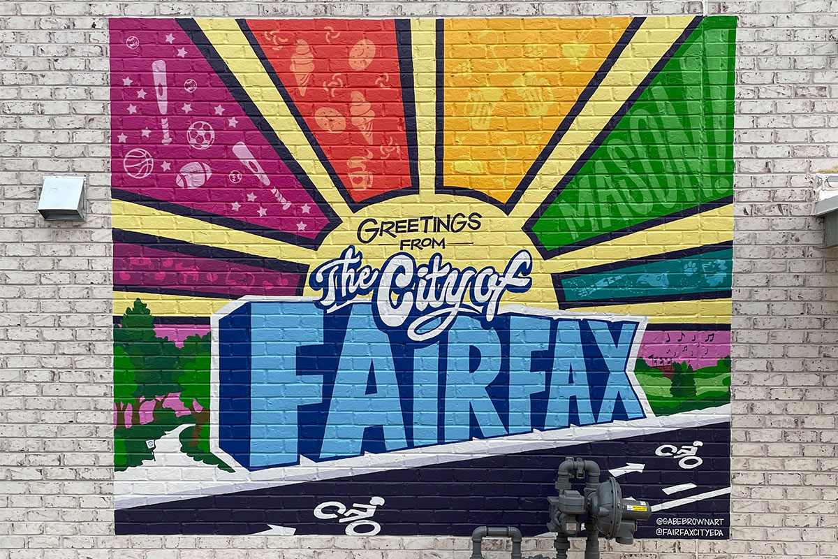 Colorful mural of a sun with the words "Greetings from the City of Fairfax"