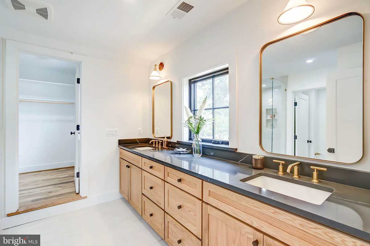 bathrrom with double vanity and walk-in closet
