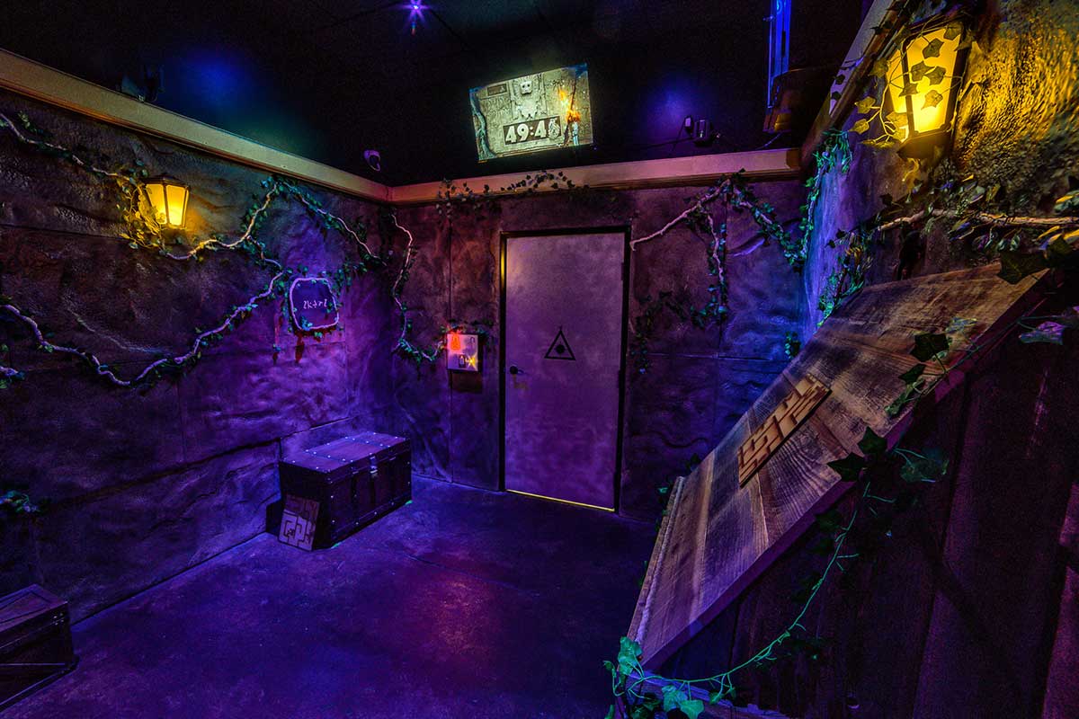 dark escape room with vines on the wall