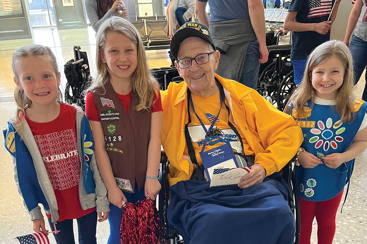 veteran taking picture with local girl scouts