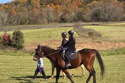 2 people riding horses at River Chase Equestrian Center