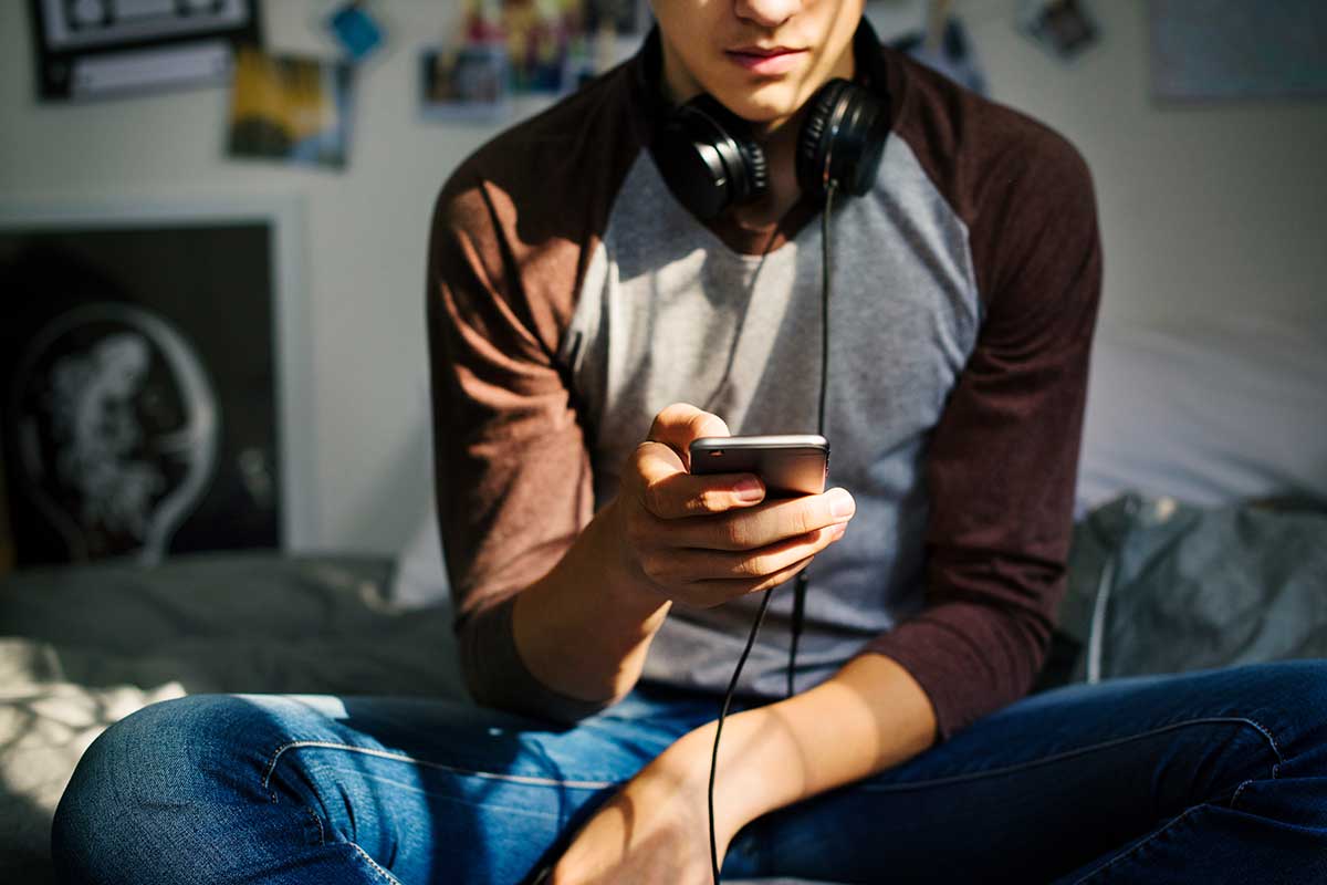 teen listening to music in bedroom