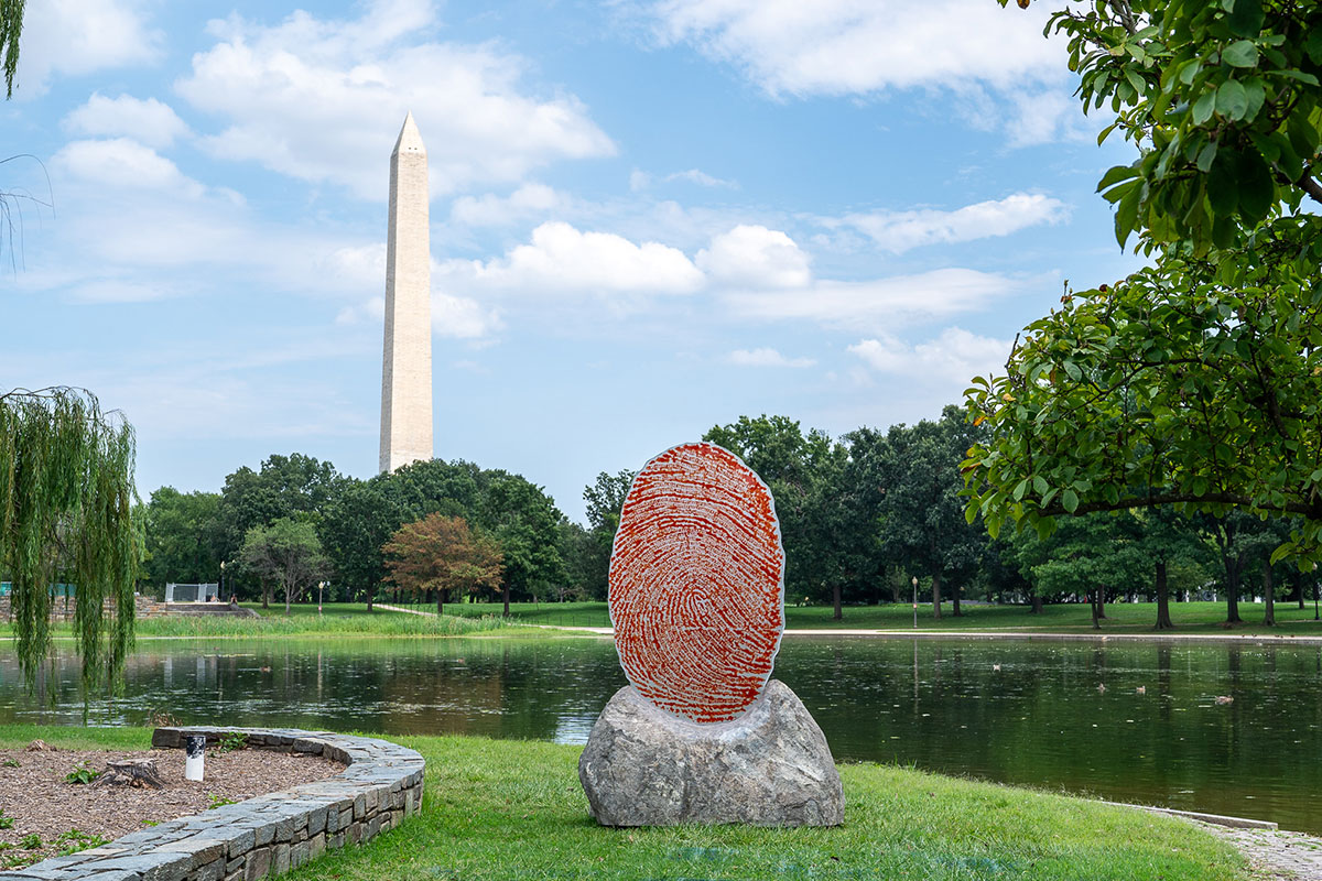 Large red fingerprint statue in front of Washington Monument