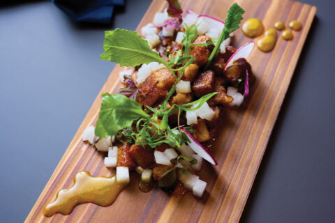 Dish from Jiwa Singapura with cubes of meat, radish, and greens