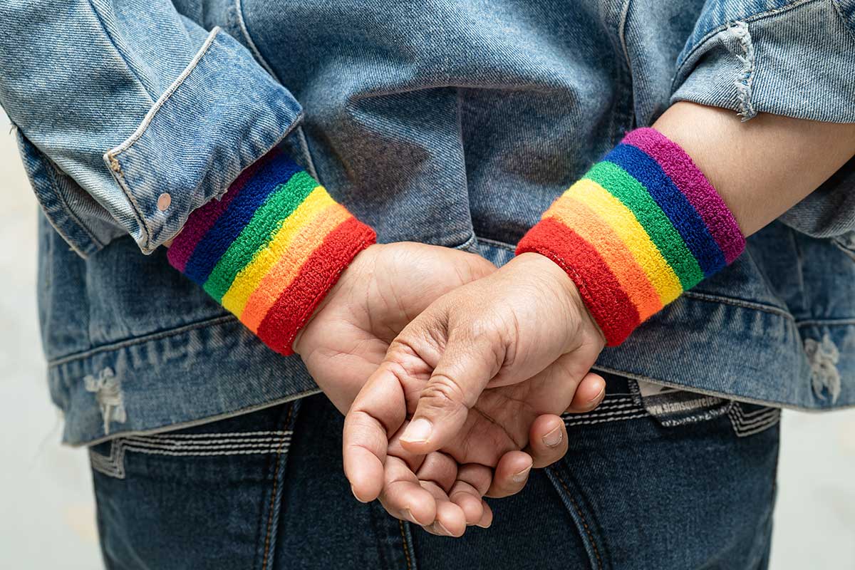 back of a child wearing a jean jacket and rainbow wristband